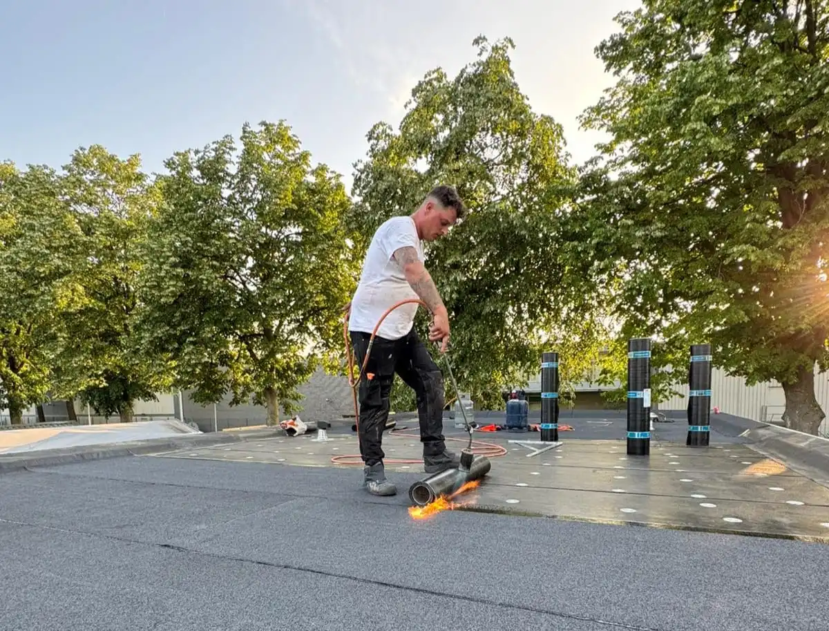 Dakdekker van VD Broek Dakonderhoud aan het werk op een plat dak